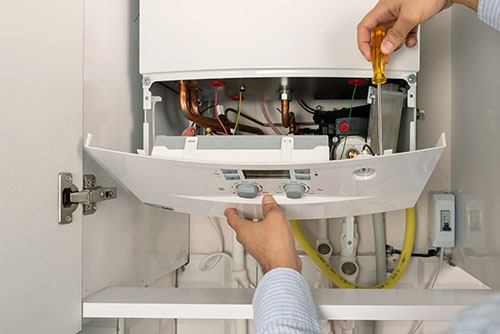 HVAC technician repairing an indoor boiler in Midvale