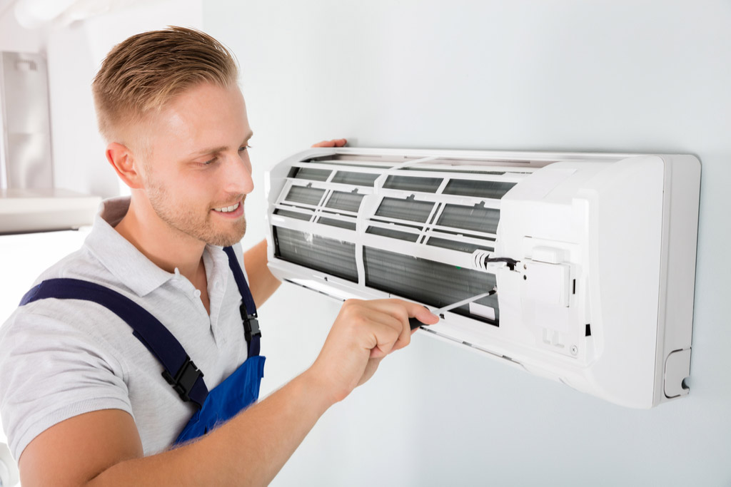 HVAC technician performing ductless air conditioning maintenance in Midvale