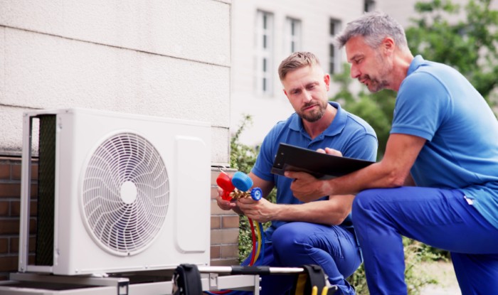 HVAC technicians installing an outdoor air conditioning unit in Midvale