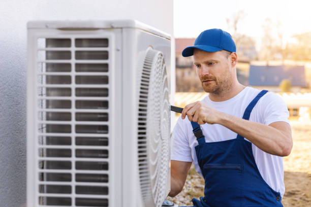 HVAC technician servicing an outdoor air conditioning unit in Midvale