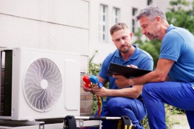 ac-installation-in-claremont-ca HVAC technicians reviewing an outdoor air conditioning unit in Midvale, UT