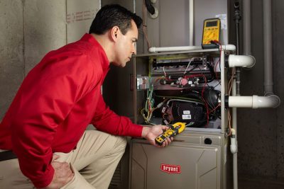 furnace repair Heating and air conditioning technician servicing an indoor furnace in Midvale, UT